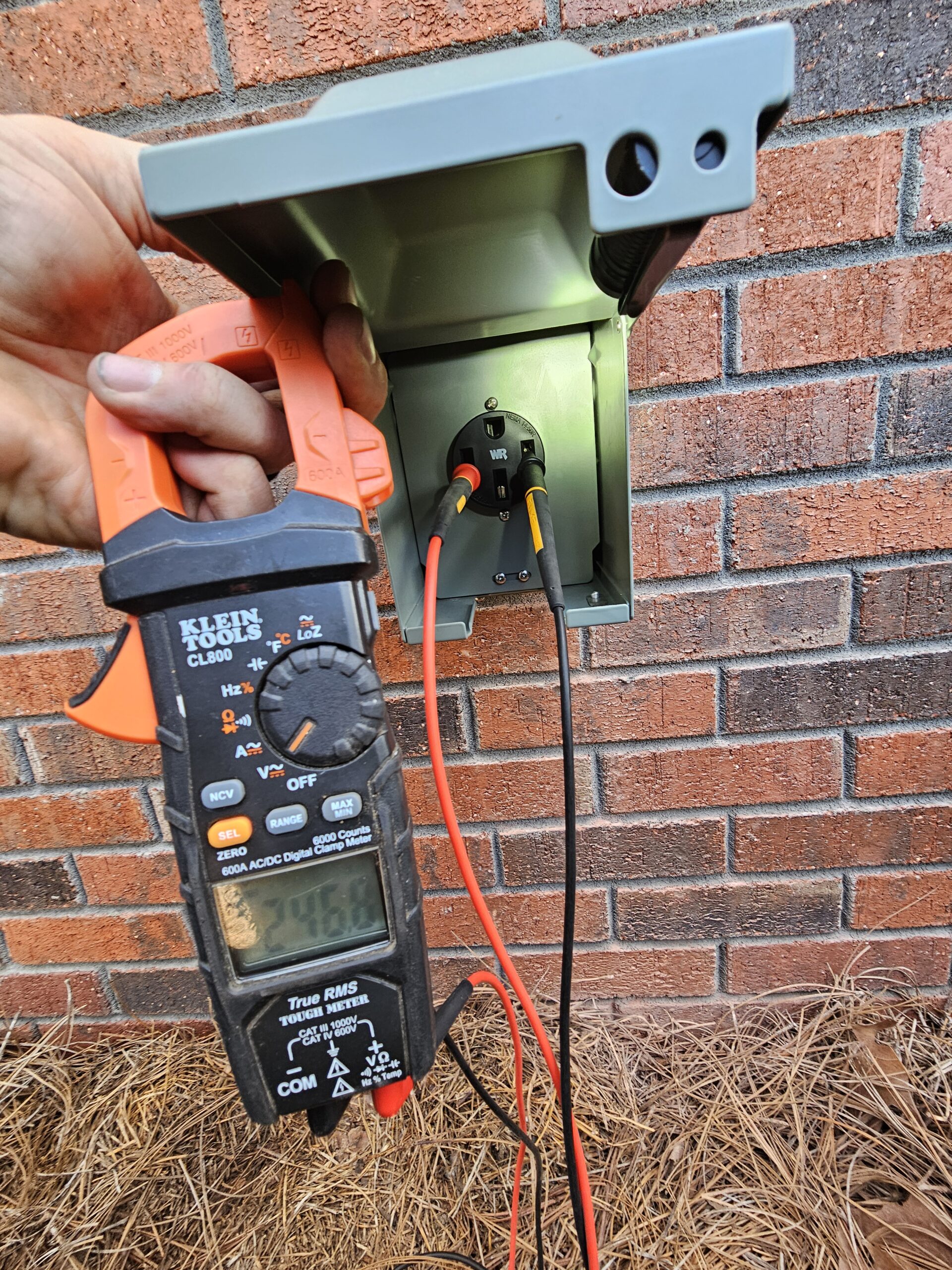 A hand holding a digital multimeter.